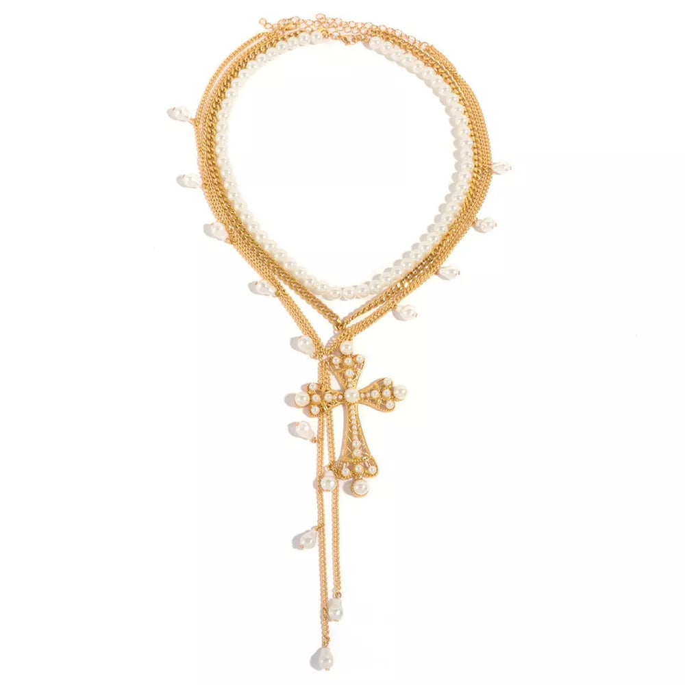 Gold layered necklace with pearl accents and a pearl-encrusted cross pendant.