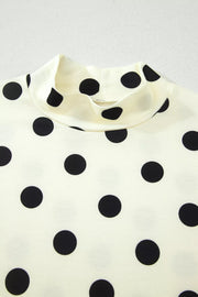 Cream polyester t-shirt with black polka dots and a high neck.
