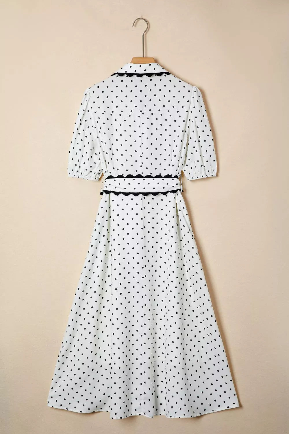 White polka dot midi dress with black trim and tie belt