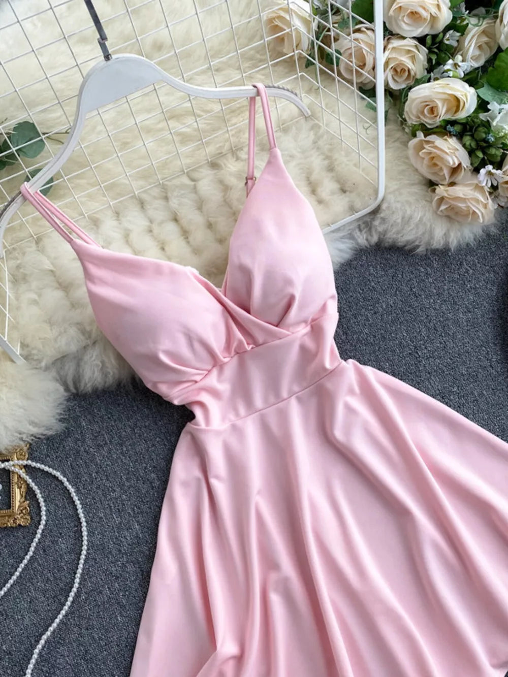 Pink V-neck spaghetti strap mini dress with adjustable straps and a draped bodice.