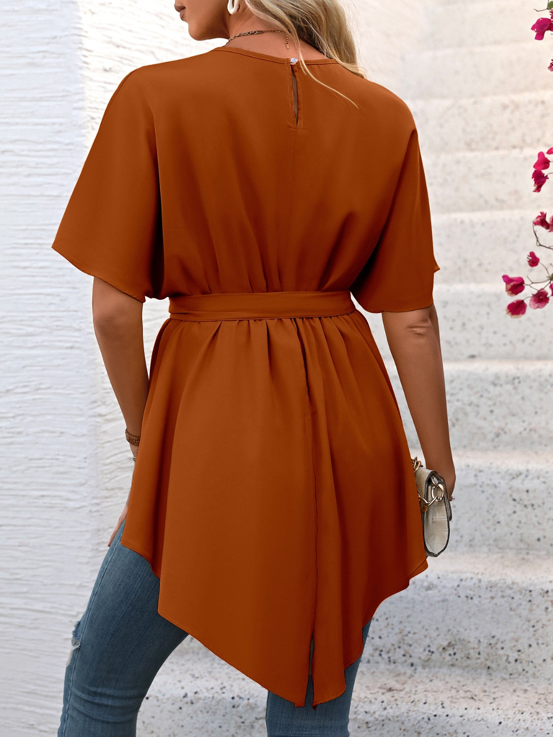 Caramel asymmetrical hemline tie-waist blouse with short sleeves and a keyhole back.