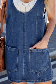 Sculpted denim mini dress in medium wash with front pockets and a scoop neckline.