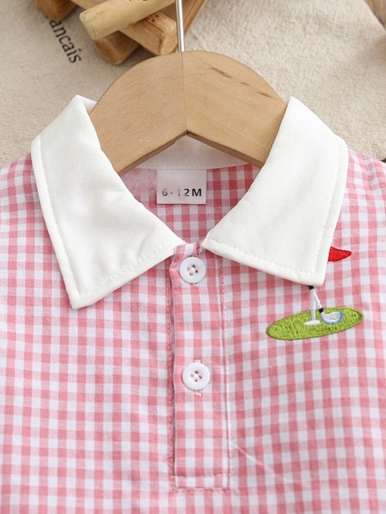 Baby pink gingham polo dress with white collar and golf embroidery detail.