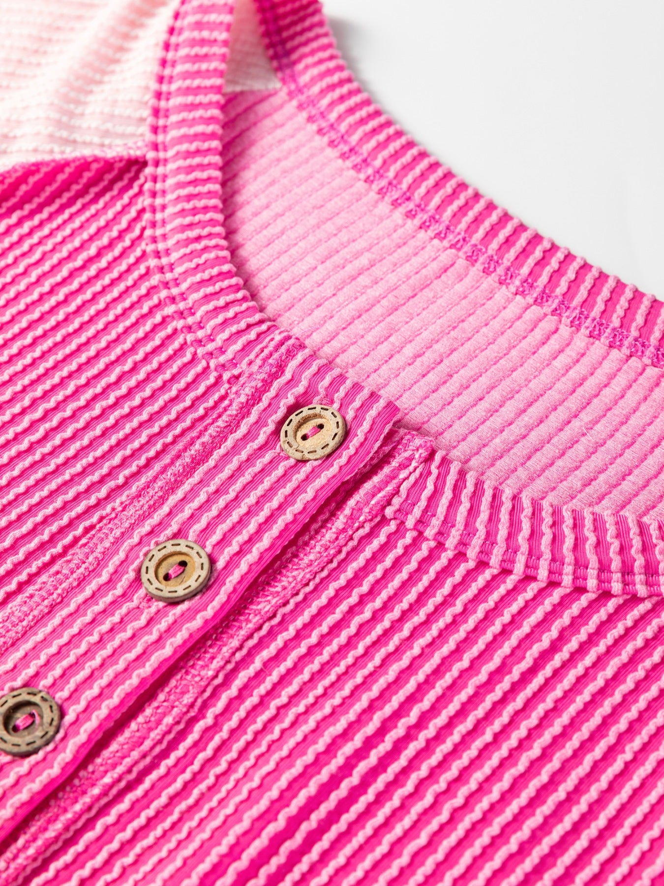 Color block henley t-shirt in fuchsia pink with textured stripes and button detail.