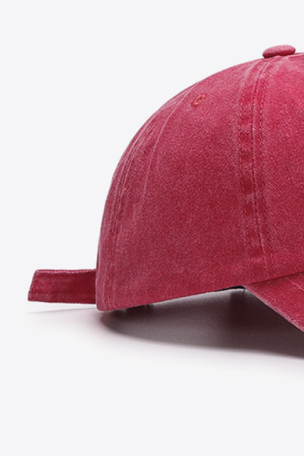 Washed cotton baseball cap in pink with adjustable strap detail.