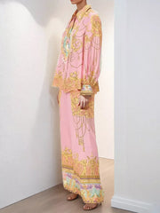 Pink baroque print two-piece set with lantern sleeves and wide-leg pants.