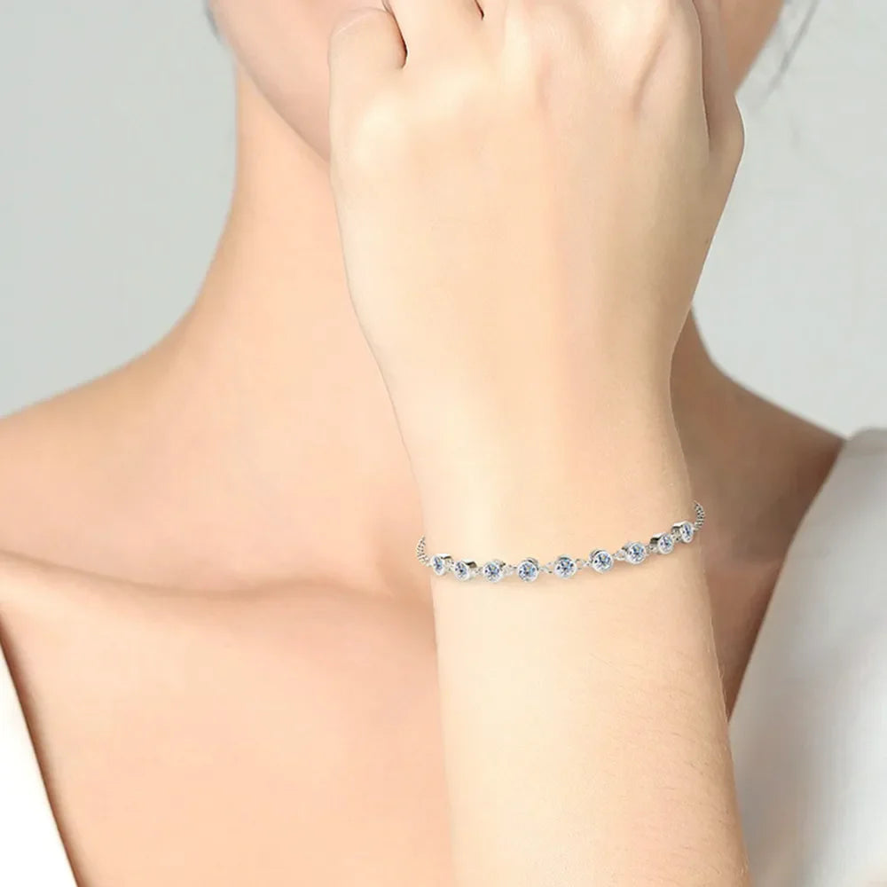 Silver moissanite tennis bracelet with bezel-set stones.