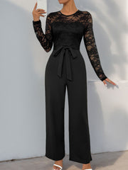 Black lace bodice wide-leg jumpsuit with long sleeves and a tie waist.