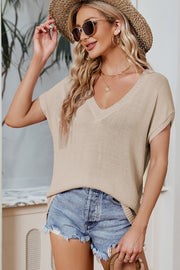 Tan knit tee with V-neck and dolman sleeves, styled with denim shorts.