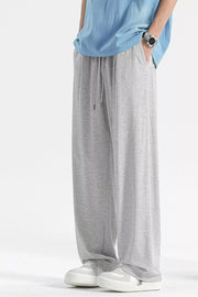 Light gray sweatpants with drawstring and pockets, styled casually.