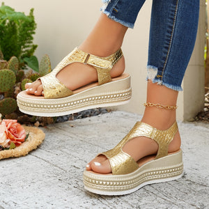 Gold crocodile-embossed platform sandals with adjustable buckle strap.