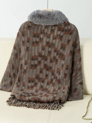 Textured plaid acrylic poncho with faux fur collar and fringe hem in brown tones.