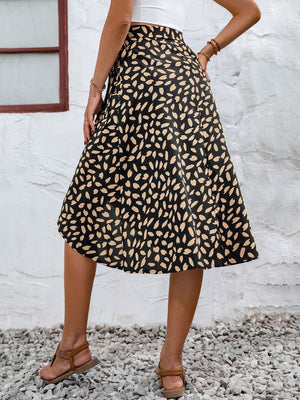 Asymmetric wrap skirt in black with abstract tan print, midi length.