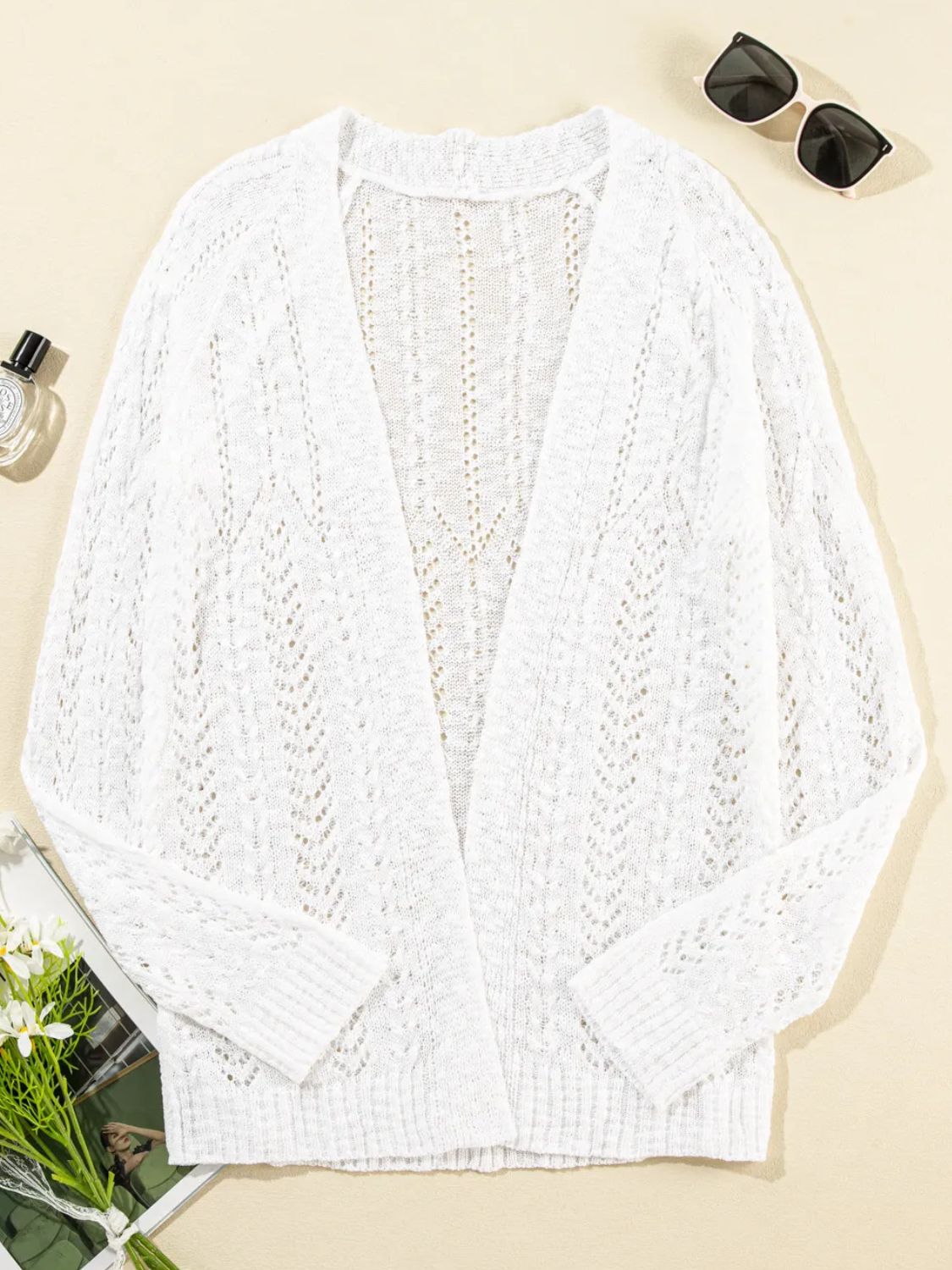 White openwork chevron knit cardigan with long sleeves and open front.