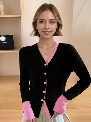 Black ribbed cardigan with pink contrast trim and buttons, long sleeves.