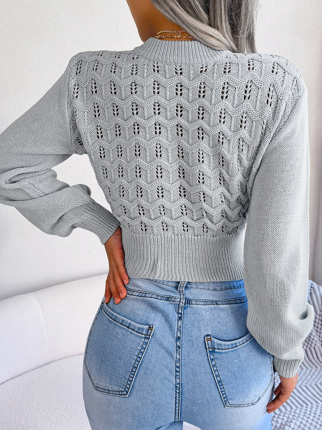 Light gray openwork puff sleeve knit sweater with textured pattern.
