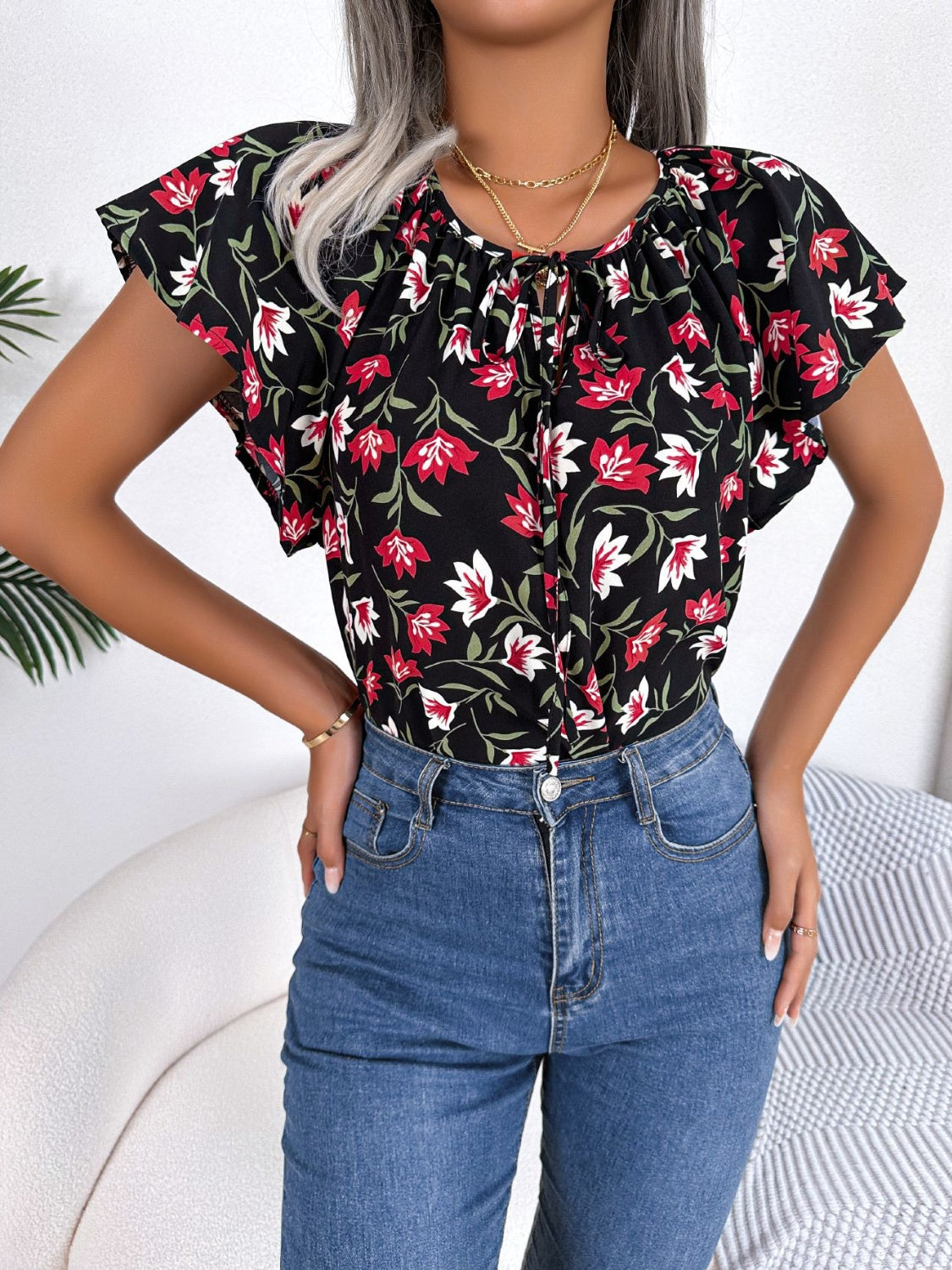 Black floral ruffle sleeve tie-neck blouse made of 100% polyester.