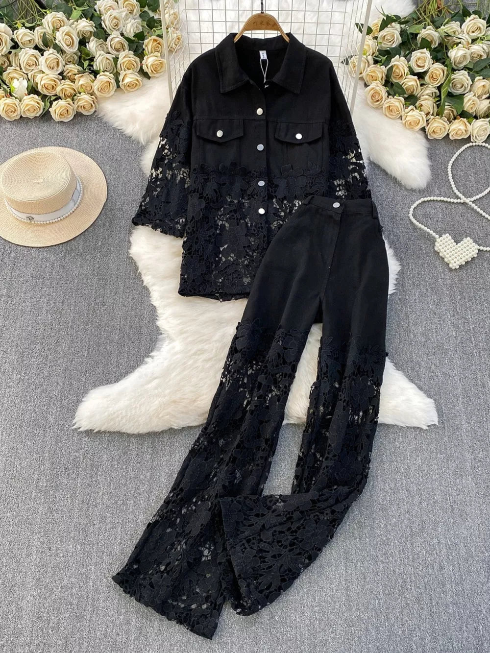 Black lace-embellished two-piece set with collared button-up jacket and wide-leg pants.