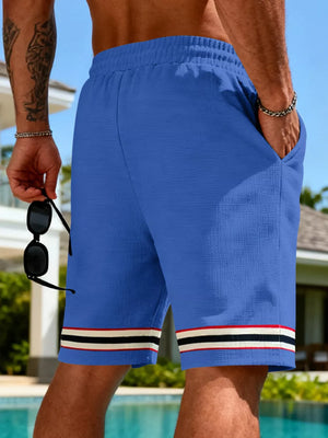 Blue textured knit drawstring shorts with pockets and striped hem detail.