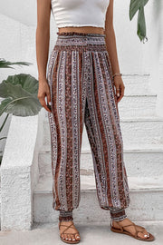 Bohemian smocked waistline trousers in multicolor with a floral stripe pattern and cinched ankles.
