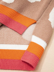 Baggy sweater in tan with a floral pattern and striped cuffs in pink, orange, and white.