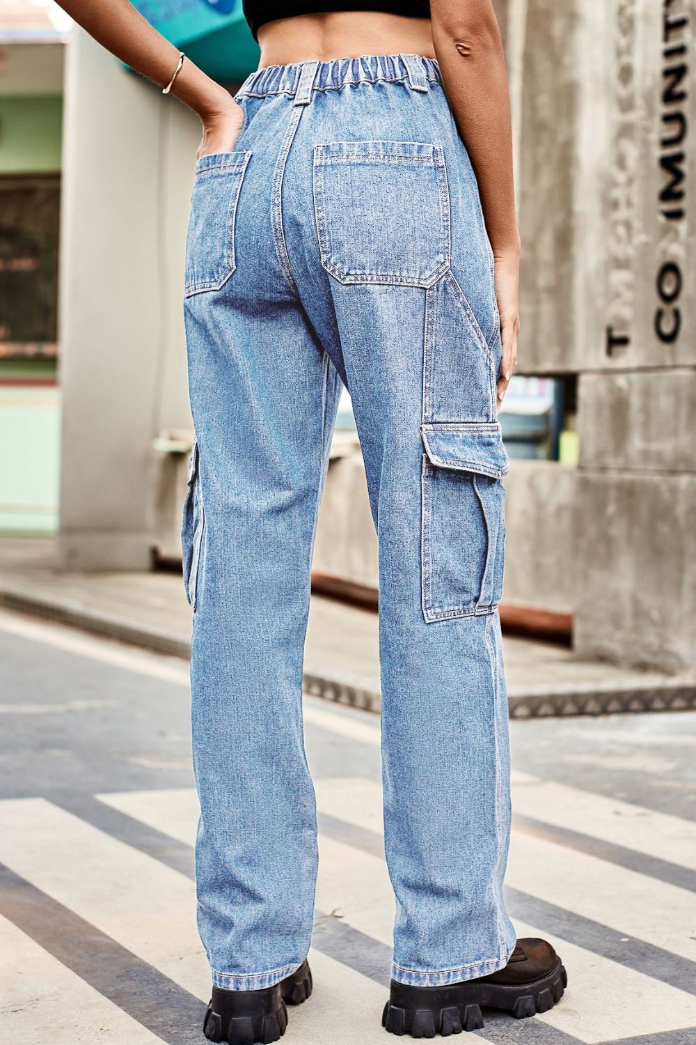 Light wash denim cargo pants with relaxed fit and elastic waistband.
