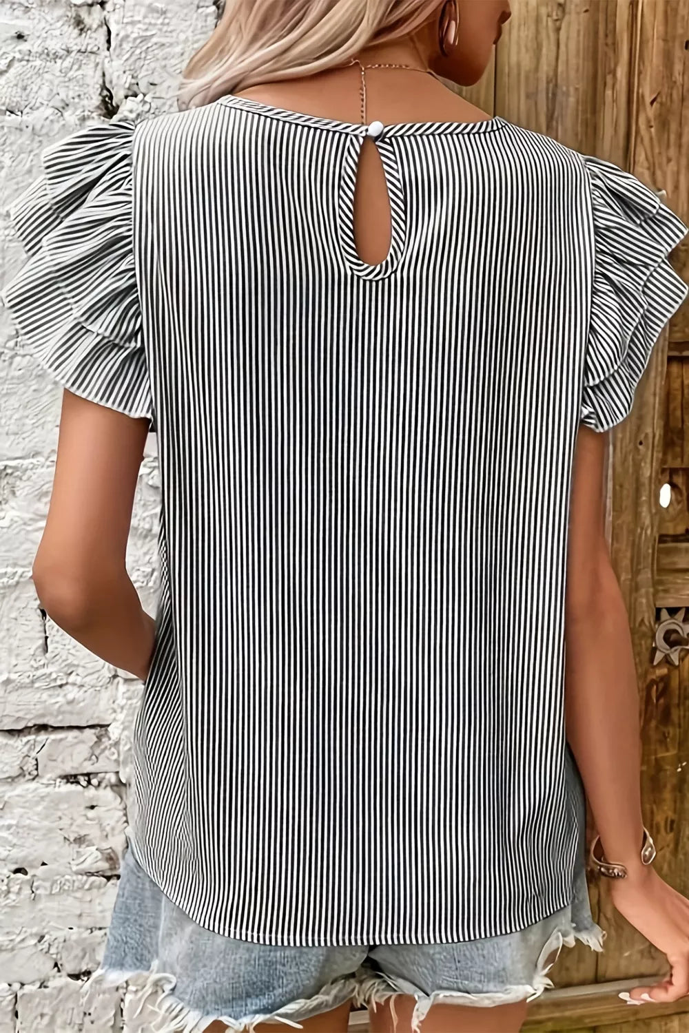 Striped polyester shirt with ruffle sleeves and keyhole back detail.