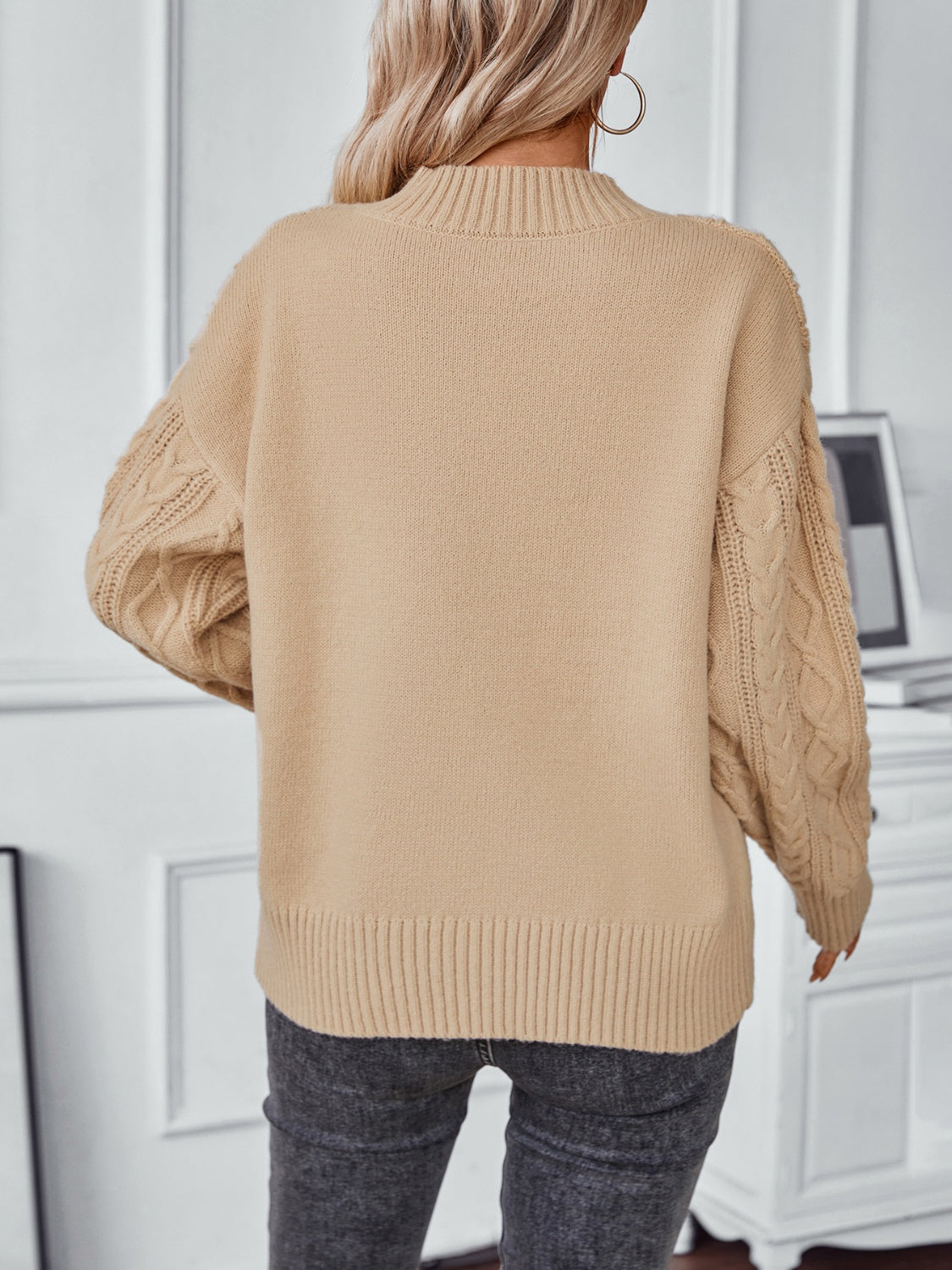 Camel cable knit sweater with mock neck and textured sleeves.