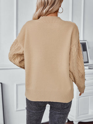 Camel cable knit sweater with mock neck and textured sleeves.