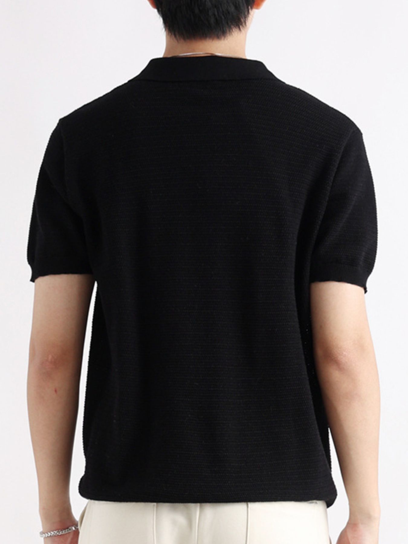 Black short-sleeve cotton polo shirt with textured knit and button detail