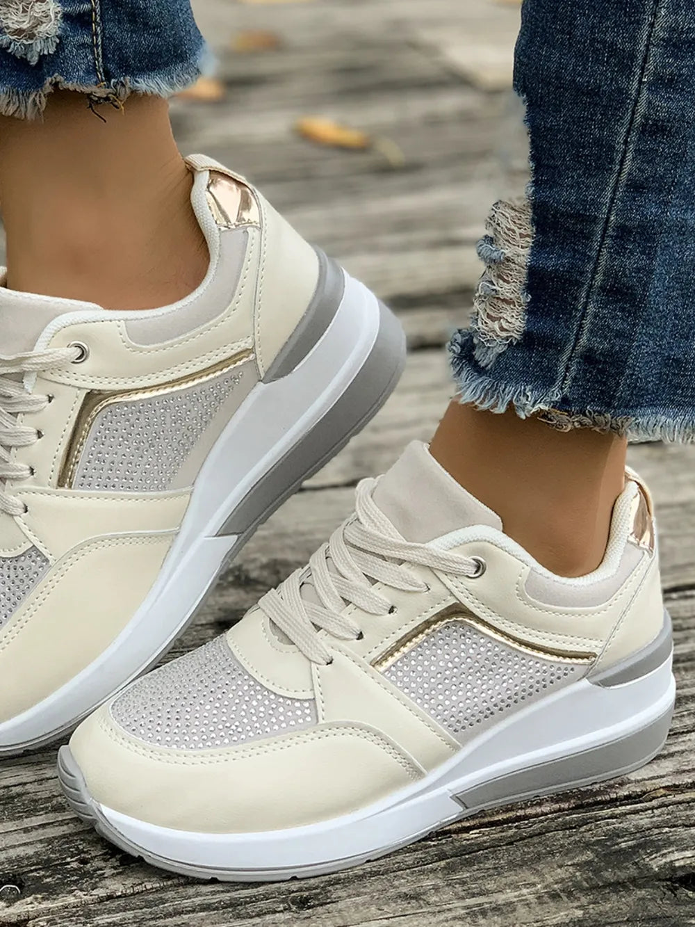 Beige platform sneakers with gemstone panel details and gold accents.
