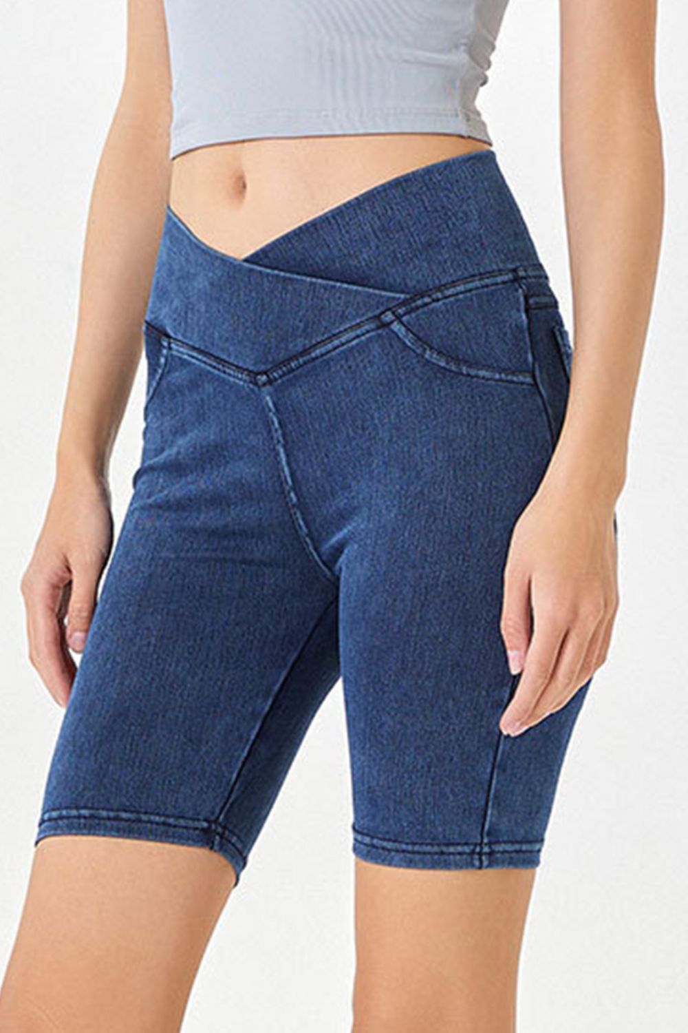 Denim bermuda shorts in medium wash with a crisscross waistband and asymmetrical detail.