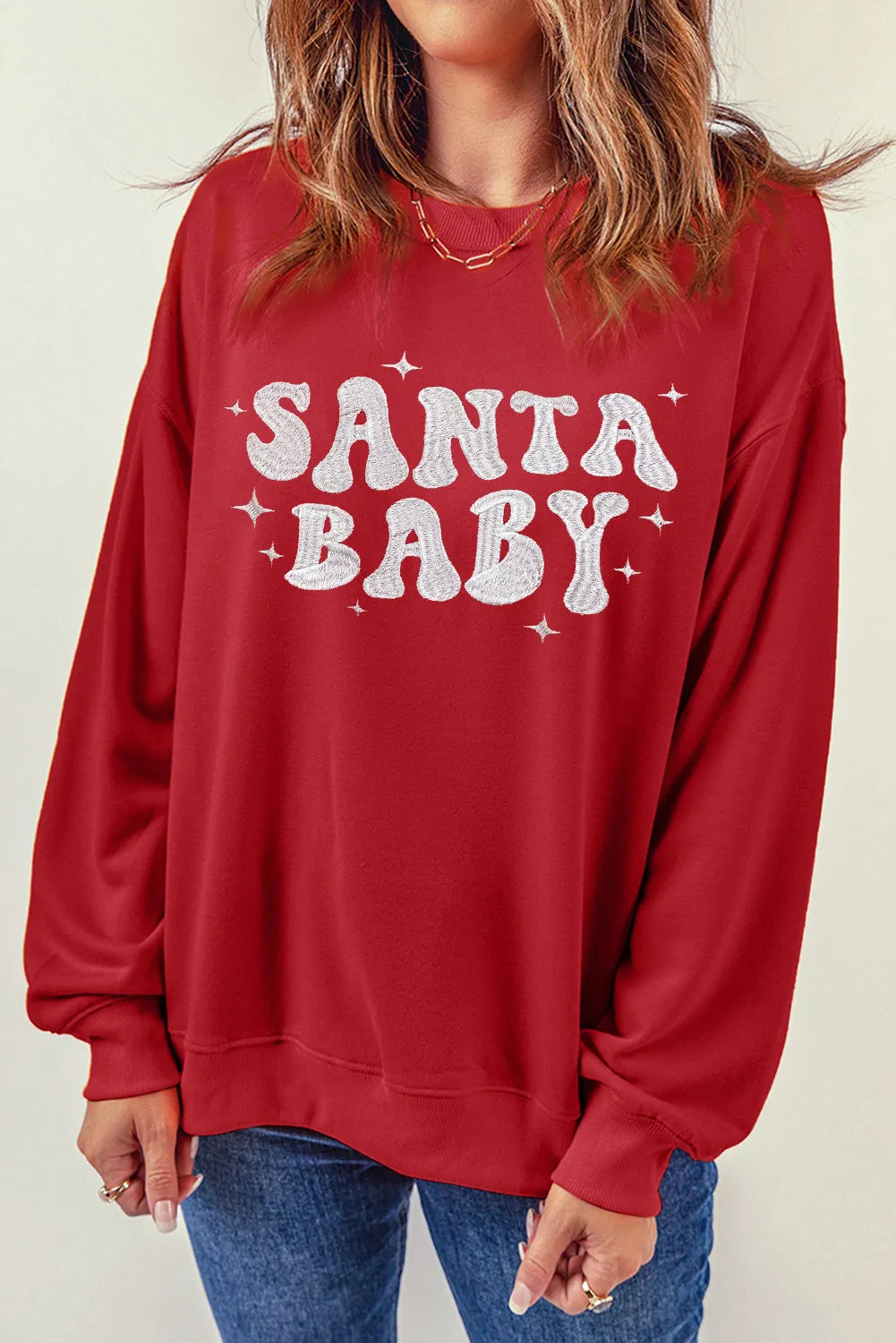 Red crewneck sweatshirt with white Santa Baby graphic and stars.