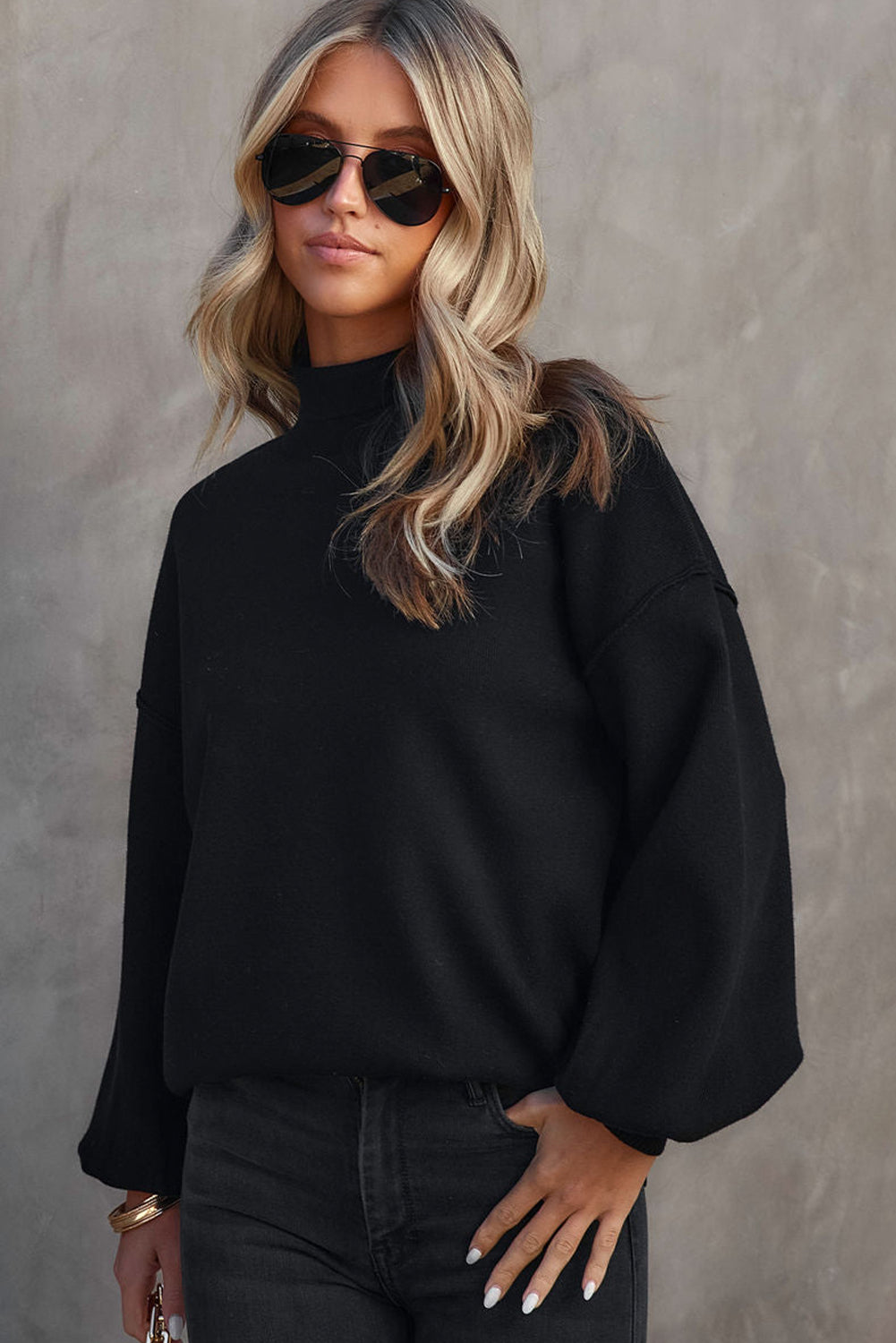 Black mock neck knit sweater with balloon sleeves and a casual fit.