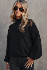 Black mock neck knit sweater with balloon sleeves and a casual fit.