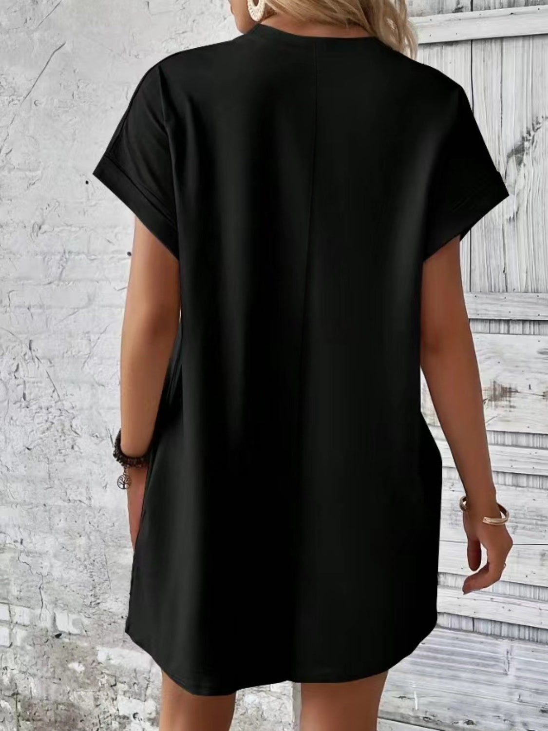Black relaxed tee dress with cuffed sleeves and pockets, casual midi length.