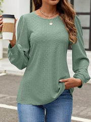 Sage green perforated puff sleeve blouse with textured pattern and cuffed sleeves.