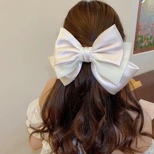 Ivory satin bow barrette hair accessory with layered loops and a knot detail.