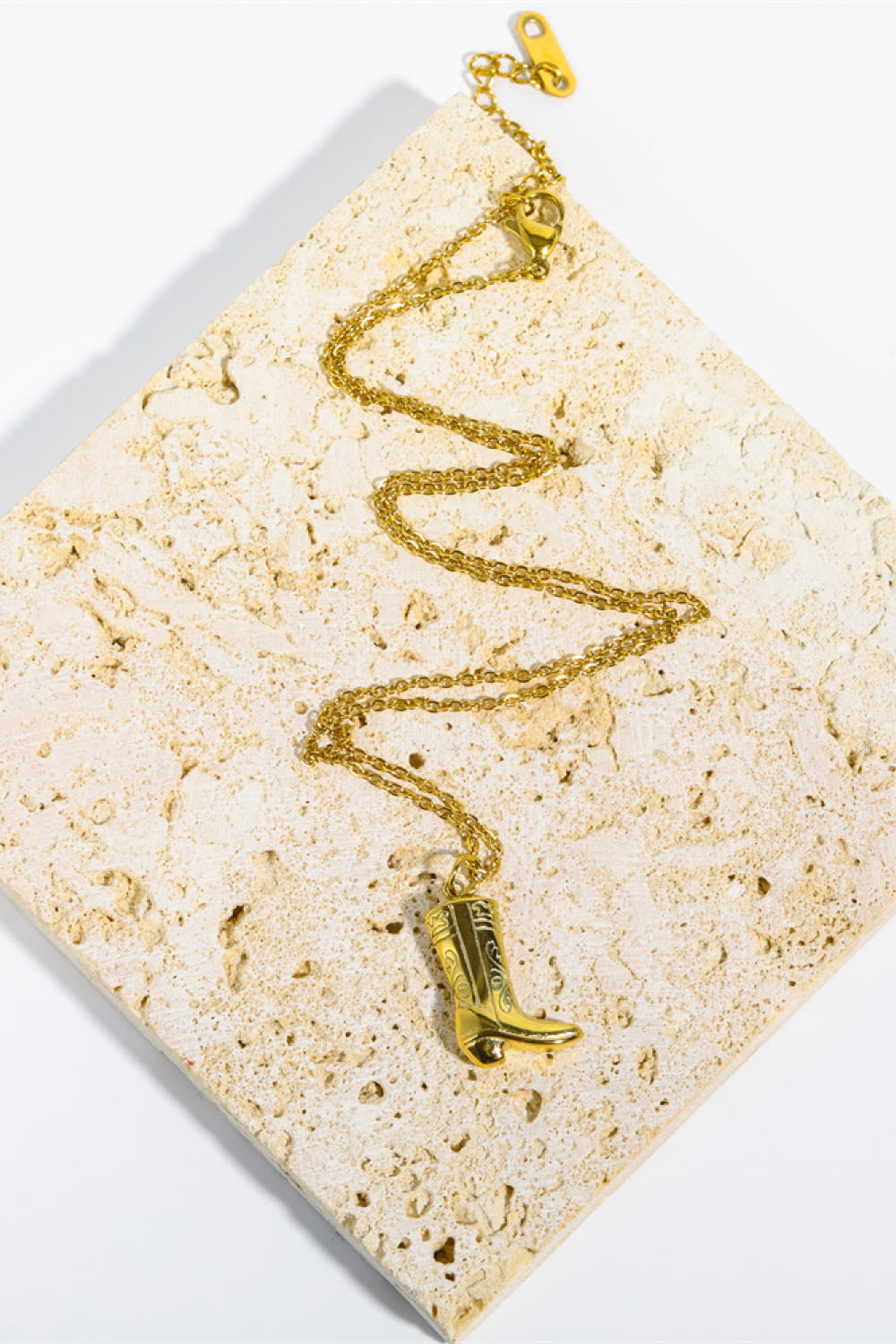 Gold cowboy boot charm necklace with intricate detailing on a delicate chain.