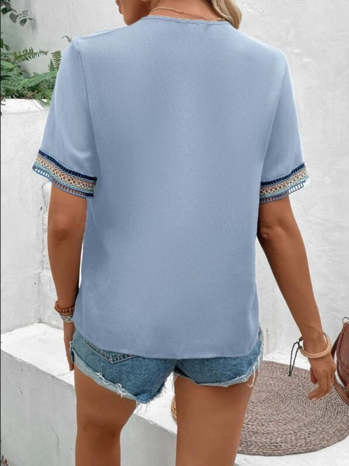 Light Blue V-neck top with embroidered trim on short sleeves.