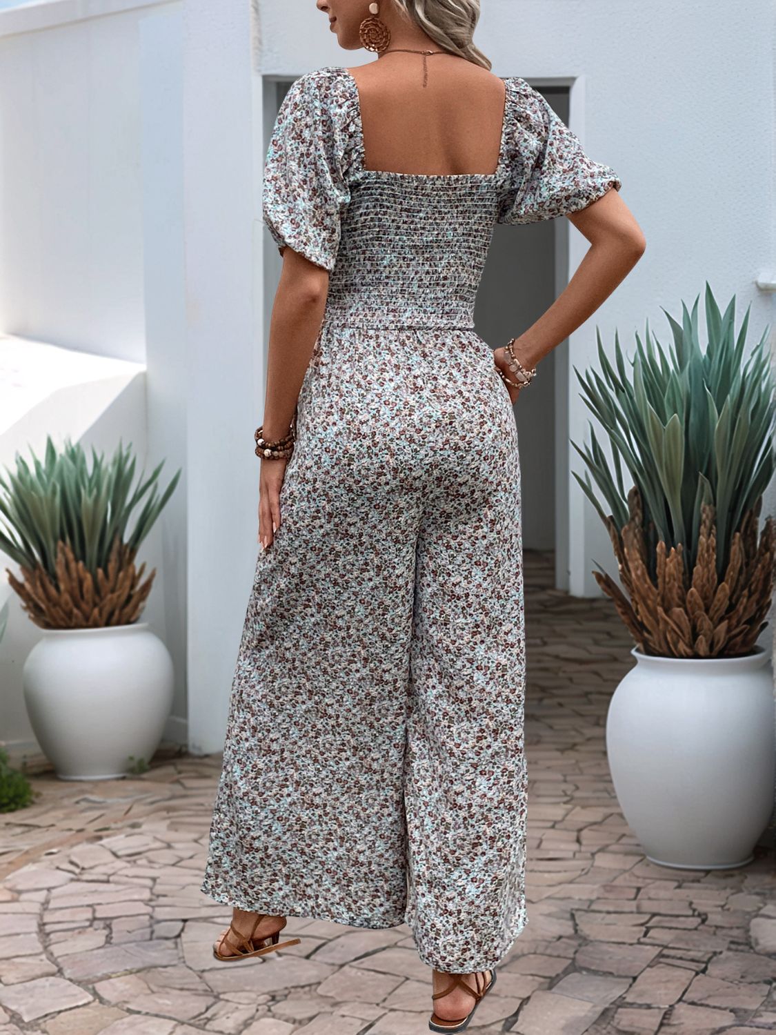 Floral smocked bodice wide leg jumpsuit with puff sleeves in a dusty pink floral print.