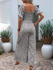 Floral smocked bodice wide leg jumpsuit with puff sleeves in a dusty pink floral print.