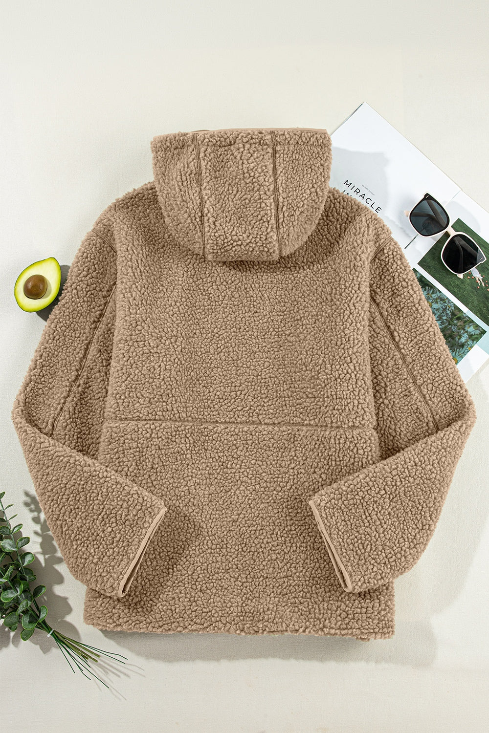 Sherpa-lined hooded jacket in brown with contrast trim and hood detail.