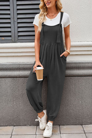 Dark Gray corduroy overalls with barrel leg and tie straps, worn with a white tee.