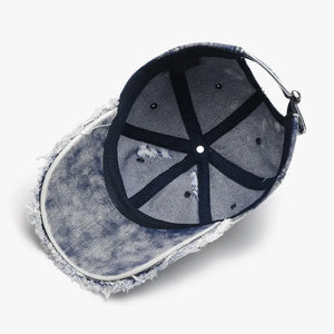 Acid wash frayed denim baseball cap with distressed brim detail.
