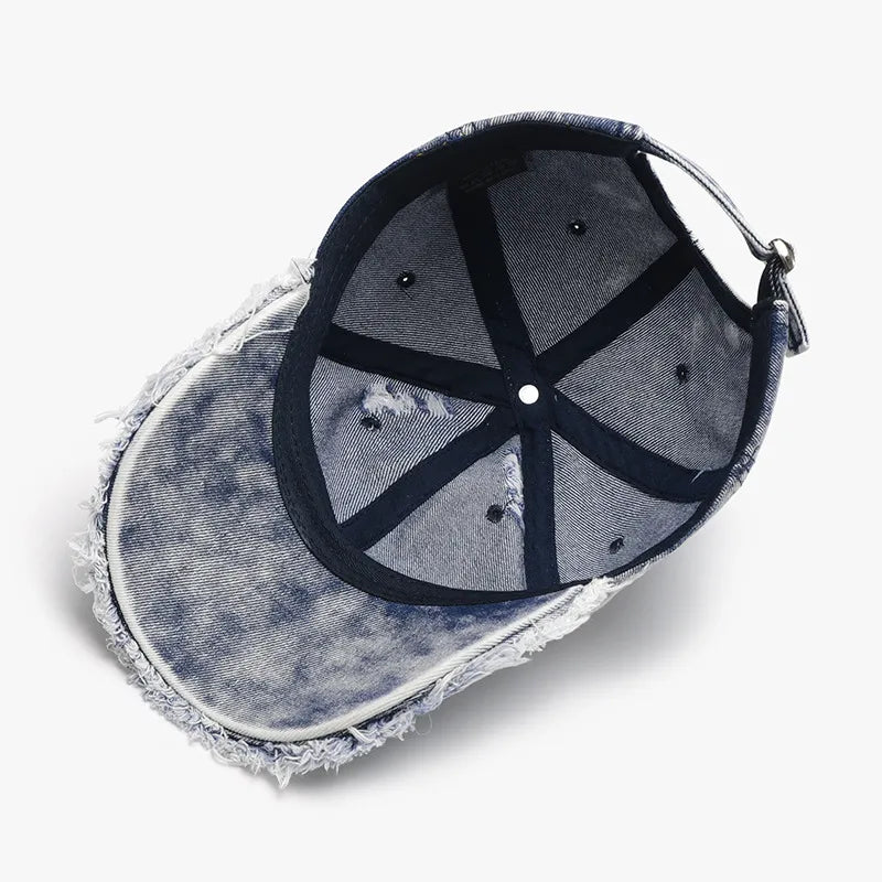 Acid wash frayed denim baseball cap with distressed brim detail.