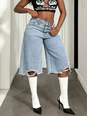 Distressed light wash denim wide-leg shorts with raw hem and thigh rips.