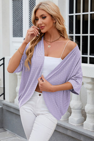 Lavender open-front crochet kimono sleeve top with a circular pattern, styled with a white cami and white pants.