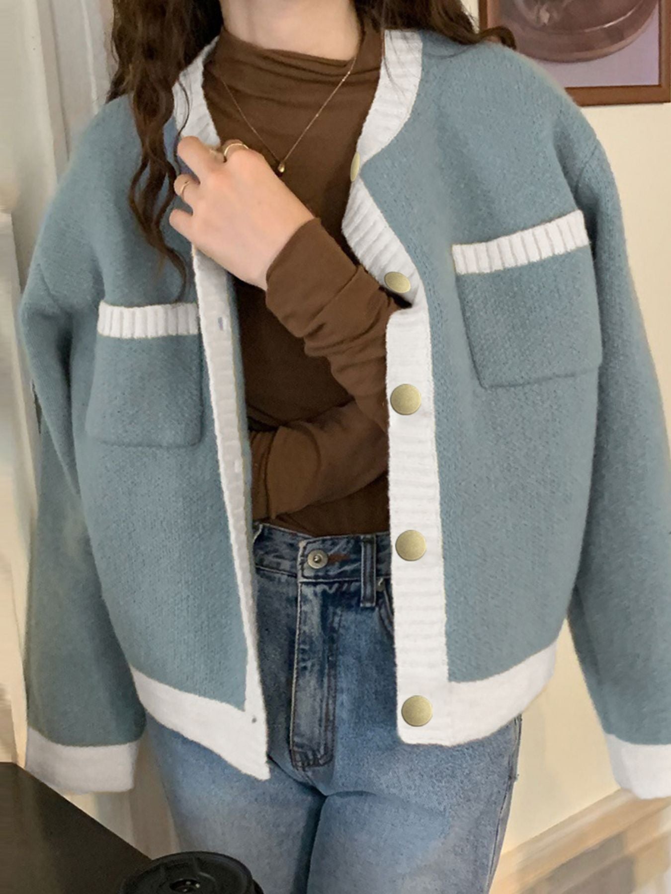 Blue acrylic cardigan with contrast trim, button up front, and patch pockets.