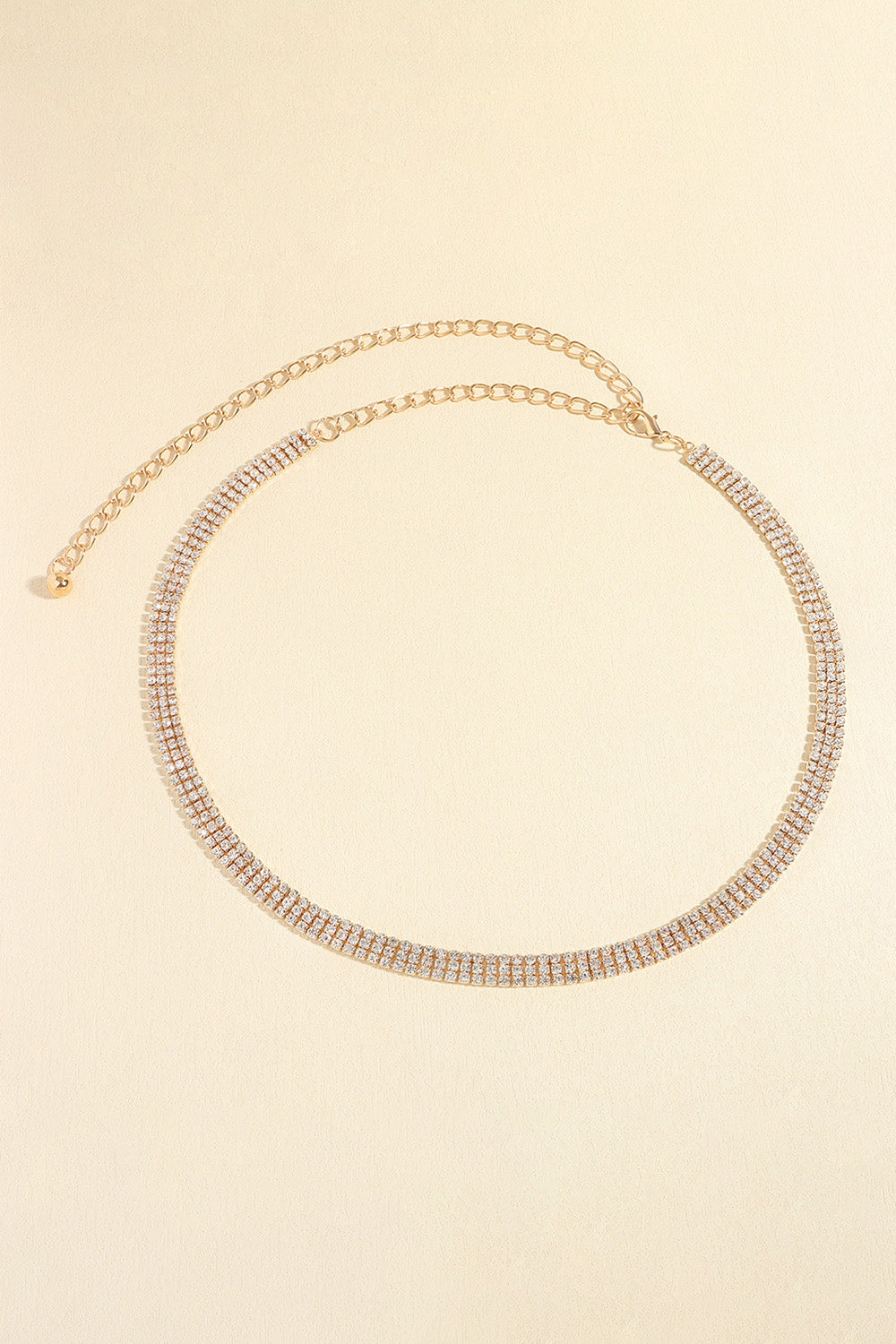 Gold triple-row crystal waist chain with adjustable link chain and clasp.